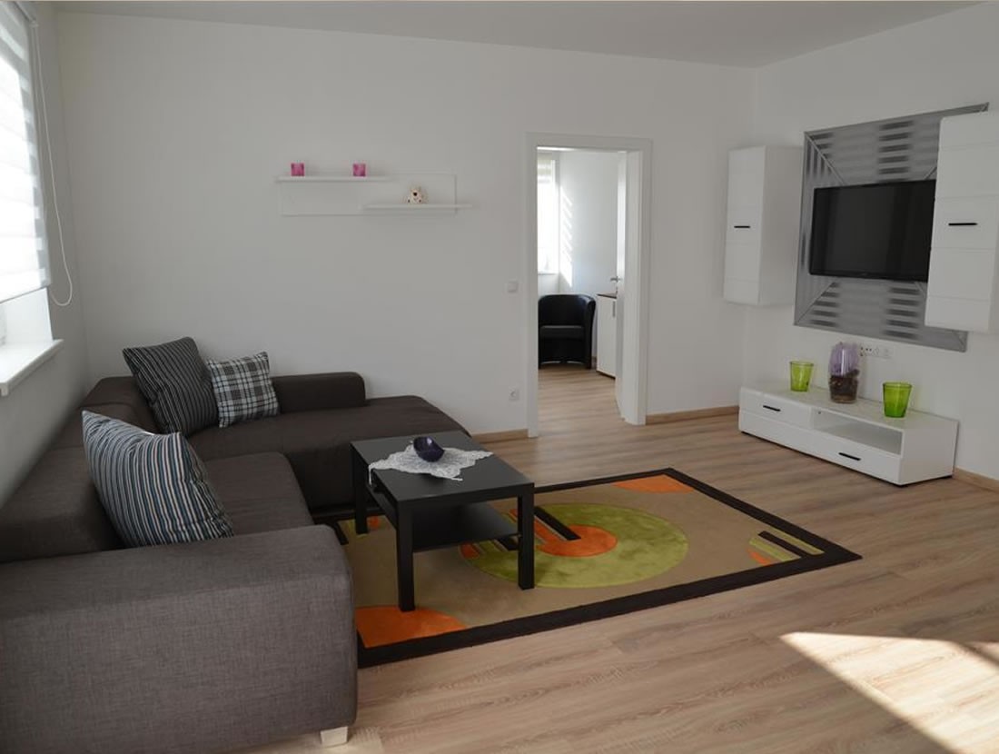 Wohnzimmer mit großer Couch und Flat-TV