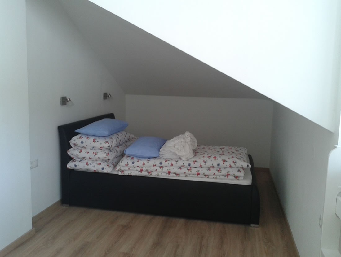 Schlafzimmer mit Doppelbett in der Mansarde